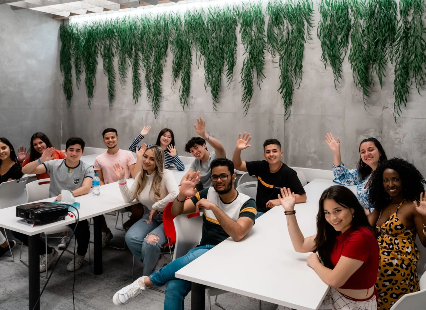 Students in a classroom raising their hands.