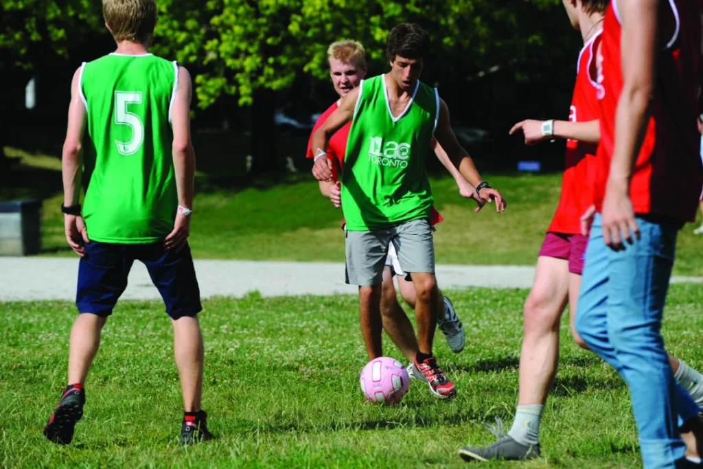  ILAC International High School students playing soccer in green and red jerseys