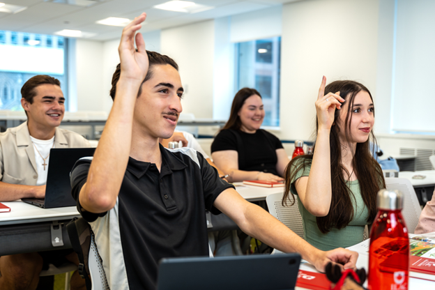 ILAC International high school students in class raising hands for recitation